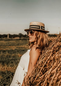 A girl in a straw hat leaned back. a tanned girl is resting in the south. summer vacation in europe.