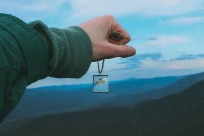 Cropped image of man against cloudy sky