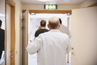 Rear view of men standing at entrance