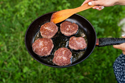 Fried cutlets in a frying pan. top view of a frying pan, woman turning cutlets with a spatula