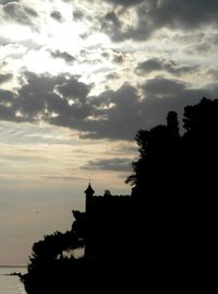 Silhouette of building against cloudy sky