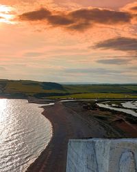 Scenic view of river against sky during sunset