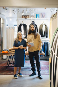 Female entrepreneur with male colleague standing in clothing stores