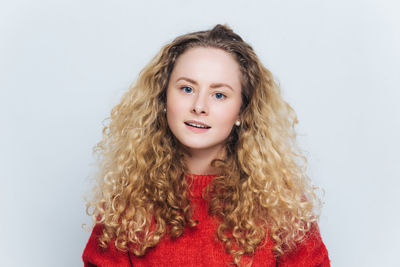 Portrait of young woman against white background