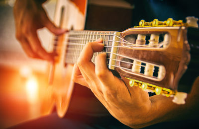 Midsection of man playing guitar