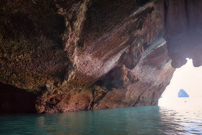 View of rock formation in sea against sky