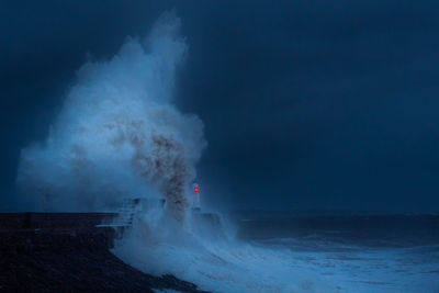 Scenic view of water splashing on cliff