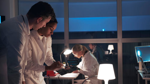 Male and female technicians working at workshop