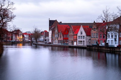 River by buildings against sky in city