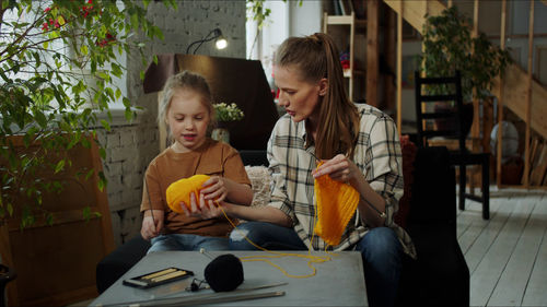 Mother teaching crocheting to daughter