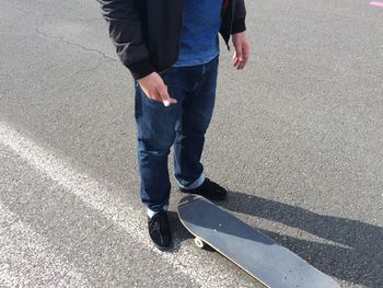 Low section of person standing near skateboard