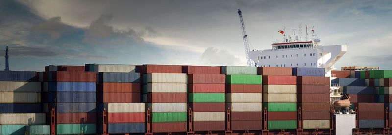 Stack of commercial dock by pier against sky