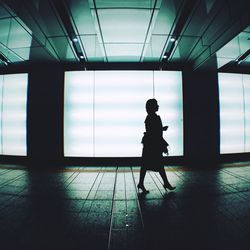 Side view of silhouette man walking against building