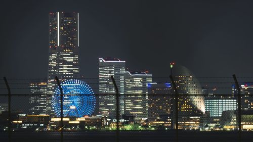 Illuminated buildings against sky at night