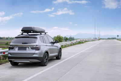 Rear view of vehicles on road against sky