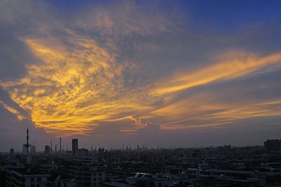 High angle view of cityscape against cloudy sky