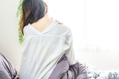 Midsection of woman sitting on sofa at home