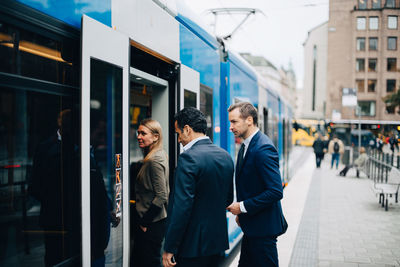 Mature business colleagues entering cable car in city