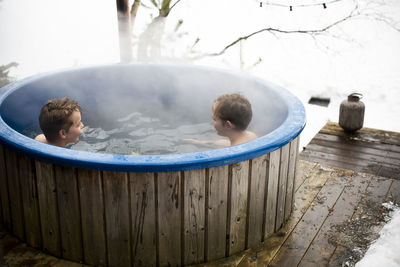 Boys enjoying in hot tub during winter