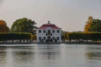 Built structure by river against clear sky