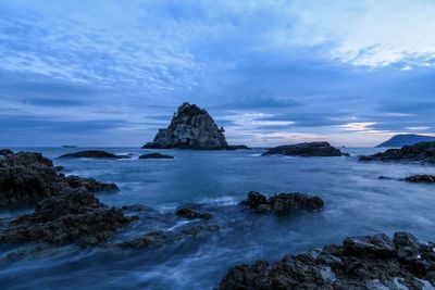 Rock formation in sea against sky