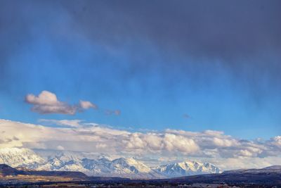 Scenic view of snowcapped mountains against blue sky