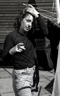 Portrait of smiling young woman standing against wall