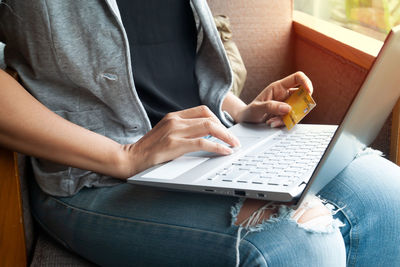 Midsection of woman using mobile phone