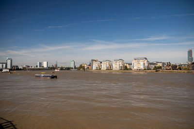 Sea by buildings against sky in city