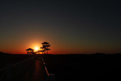 Silhouette built structure against sky during sunset