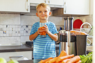 Portrait of smiling young woman preparing food at home