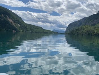 Scenic view of lake by mountains against sky