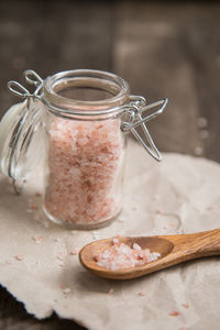 Close-up of rock salt in wooden spoon on table