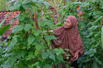 Young woman standing amidst plants