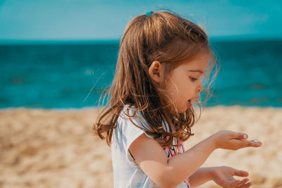 Girl holding seashell at beach