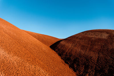 Scenic view of desert against clear blue sky