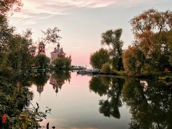 Reflection of trees in lake against sky during sunset