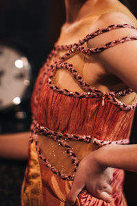 Female fashion figure in red boho dress on backstage. vertical fashion shot