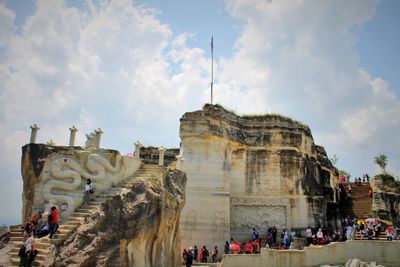 People in front of historical building against sky