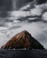 Rock formations by sea against sky