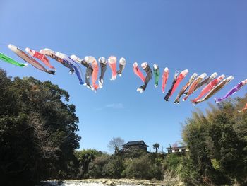 Low angle view of umbrellas hanging against clear sky