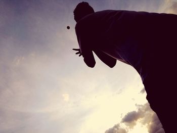 Low angle view of silhouette hand against sky during sunset