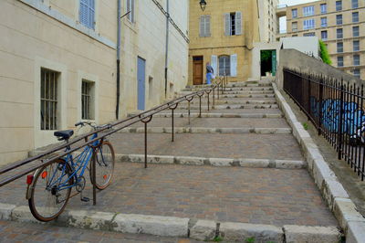 Bicycle on footpath amidst buildings in city