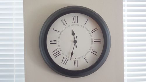 Close-up of clock mounted on wall