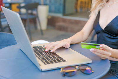 Female entrepreneur working on computer in cafe, doing online shopping
