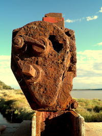 Close-up of old sculpture against sky