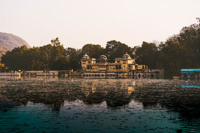 Scenic view of lake by building against clear sky