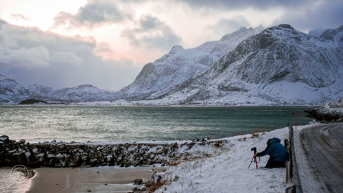 People on snowcapped mountains against sky