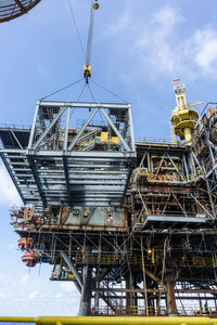 A structure deck framing being lifted from a construction work barge at oil field 