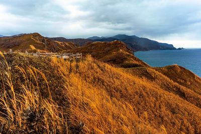 Scenic view of sea and mountains against sky